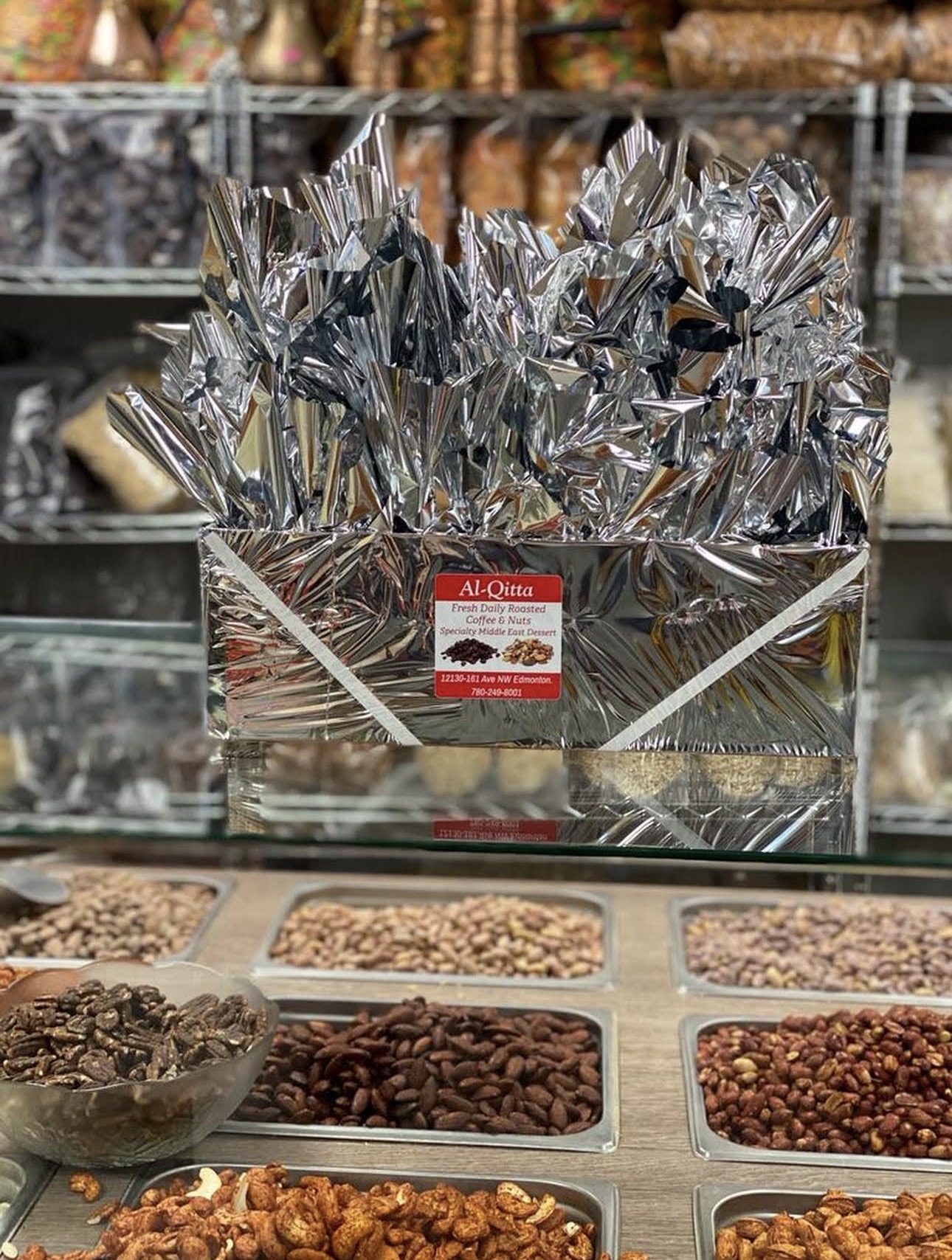 Foil-wrapped Al-Qitta gift baskets on display above the nut counter